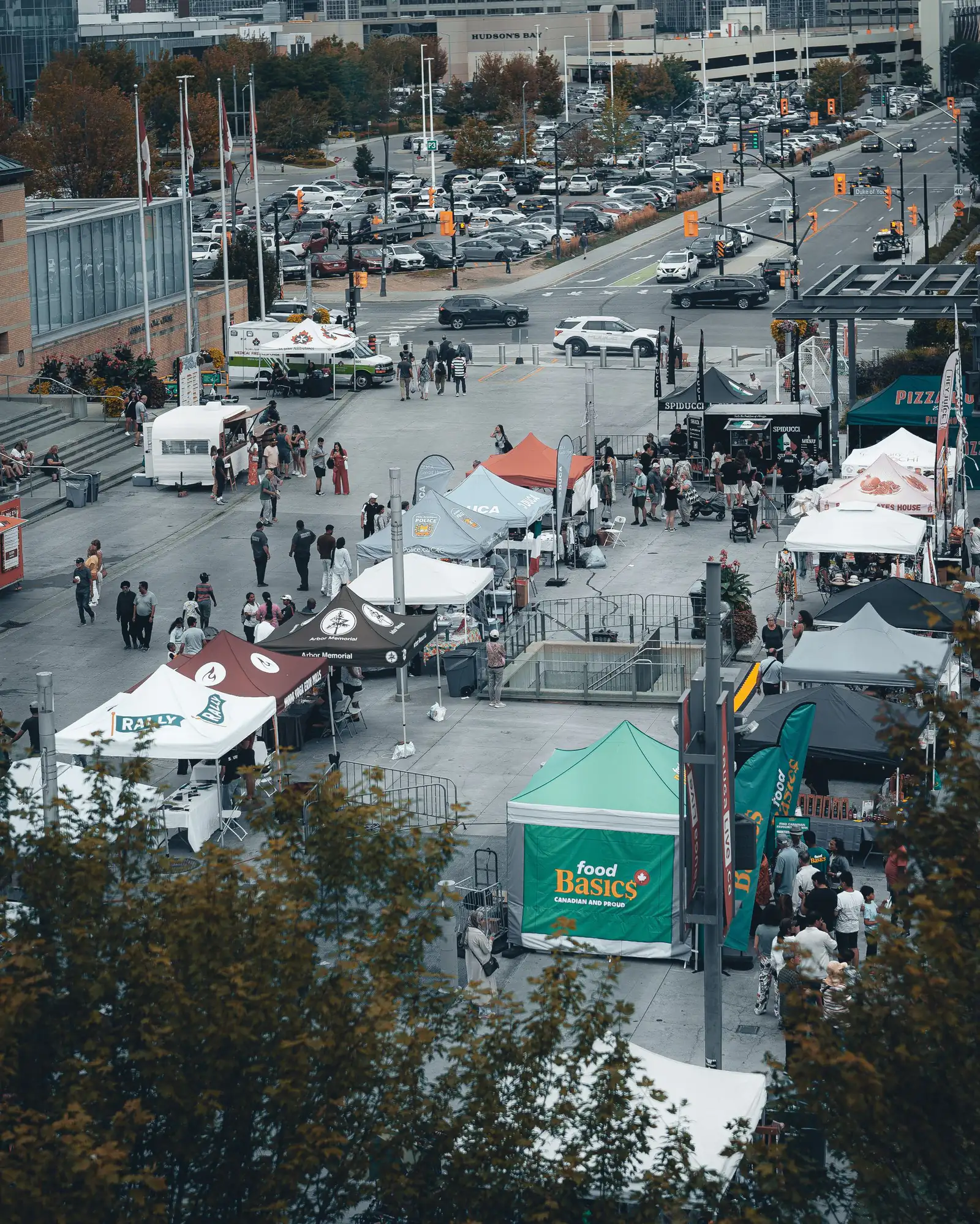 Crowds and white tents at an outdoor festival in a city square