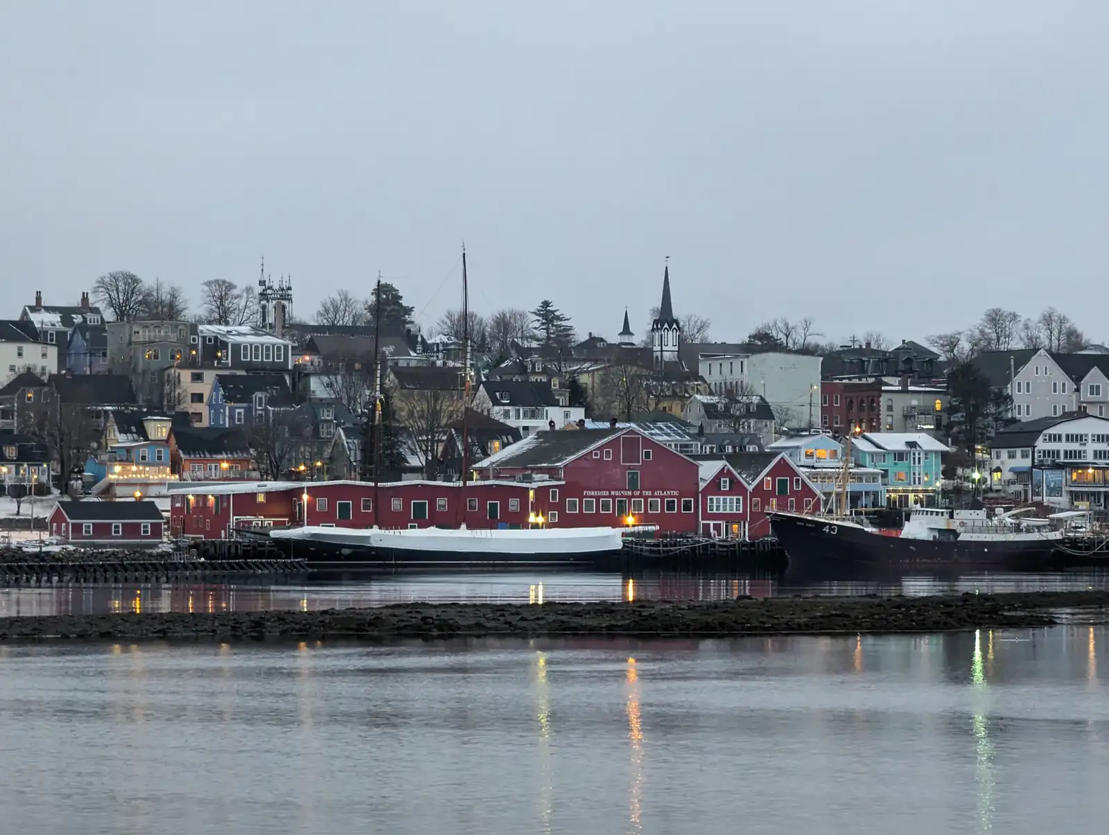 The colourful waterfront of Lunenburg, Nova Scotia, with red harbour buildings reflected in calm water
